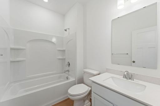This full-sized bathroom features a stylish vanity and shower-tub combination.