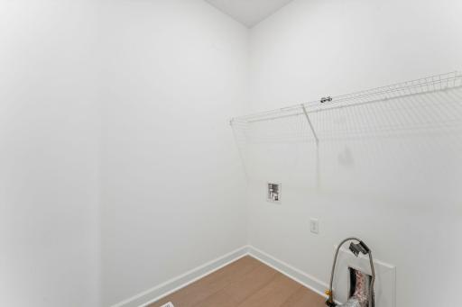 With an overhead shelf and connections for a washer and dryer, the laundry room simplifies busy chore days.