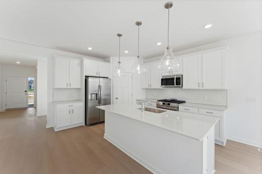 A multifunctional center island pairs with abundant cabinetry and all-new kitchen appliances to create a sleek design perfect for cooking meals of all sizes.