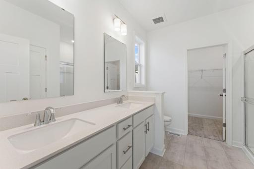 The en-suite bathroom features a glass-enclosed shower convenient double sinks