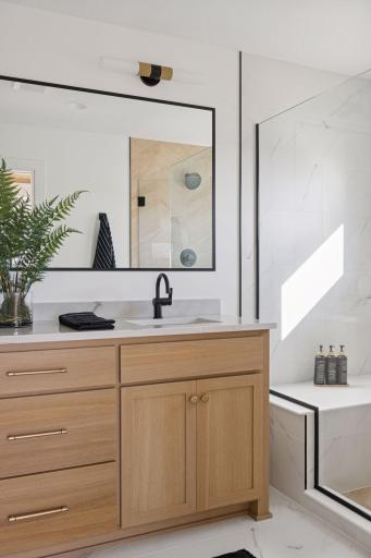 Private primary bath with large walk-in shower, bench, framed mirror