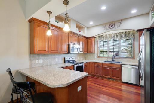 The kitchen offers Cherry Raised-Panel cabinetry with 42" uppers, Brazilian Cherry Floors, stainless appliances, breakfast bar and decorator lighted upper cubbies under 10 foot ceilings.