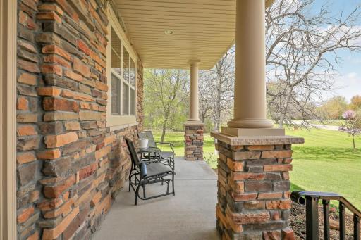 Another front porch view surrounded by beautiful stone work and attractive pillars.