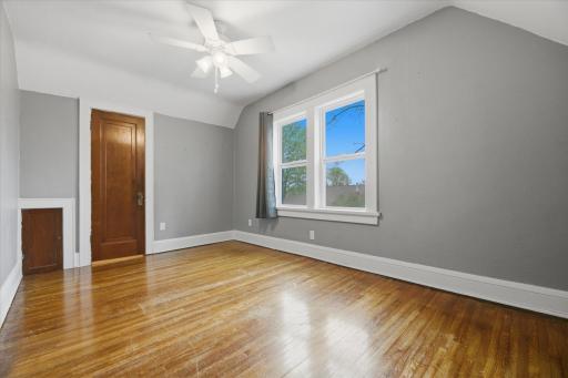 Primary bedroom measures 12.5'x14'. Original hardwoods, vinyl windows, & ceiling fan.