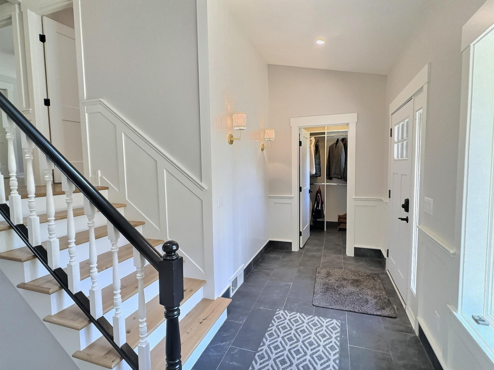 The main level also includes a spacious entryway with a large closet and new tile flooring, as well as the first bedroom. Notice the new white oak stair boards.