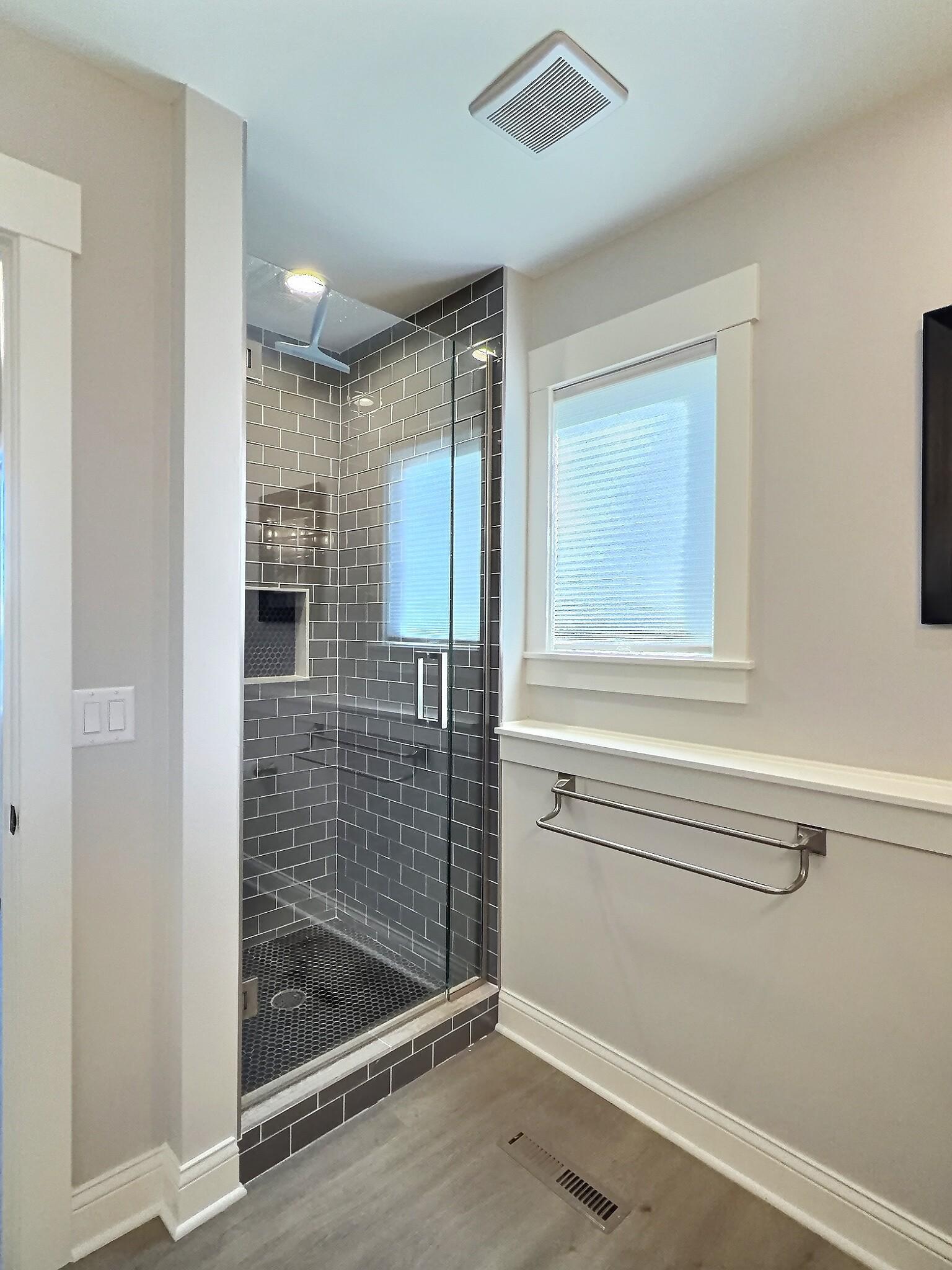 A newly remodeled bathroom on the lakeside level showcases sleek finishes and a stylish tile shower.