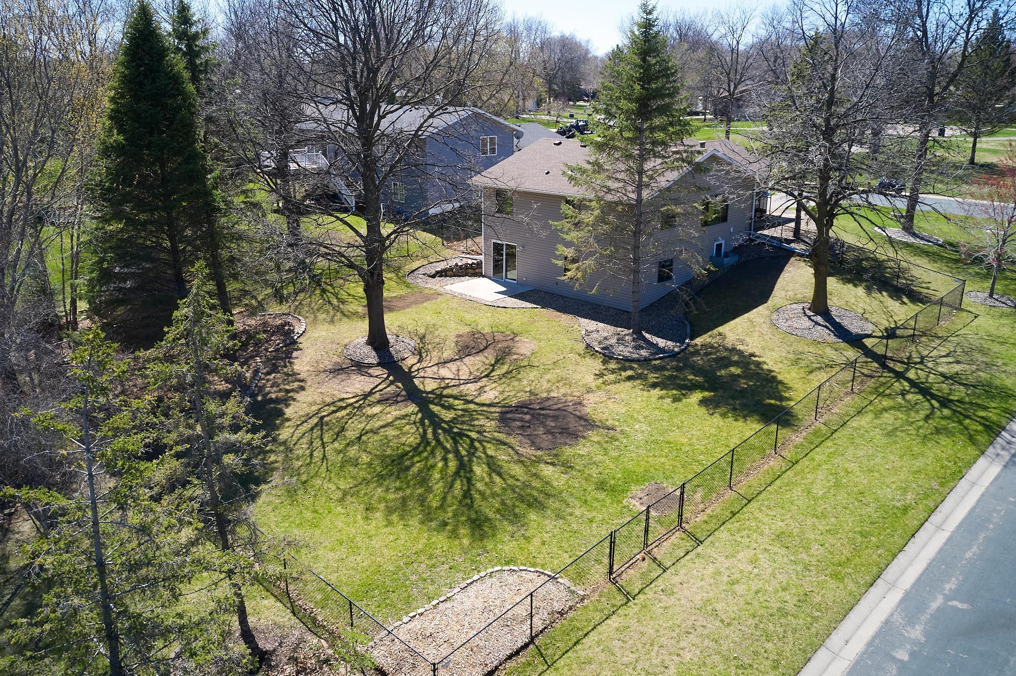 The black chain-link fence has a double-wide side gate and a single gate at the front of the home.
