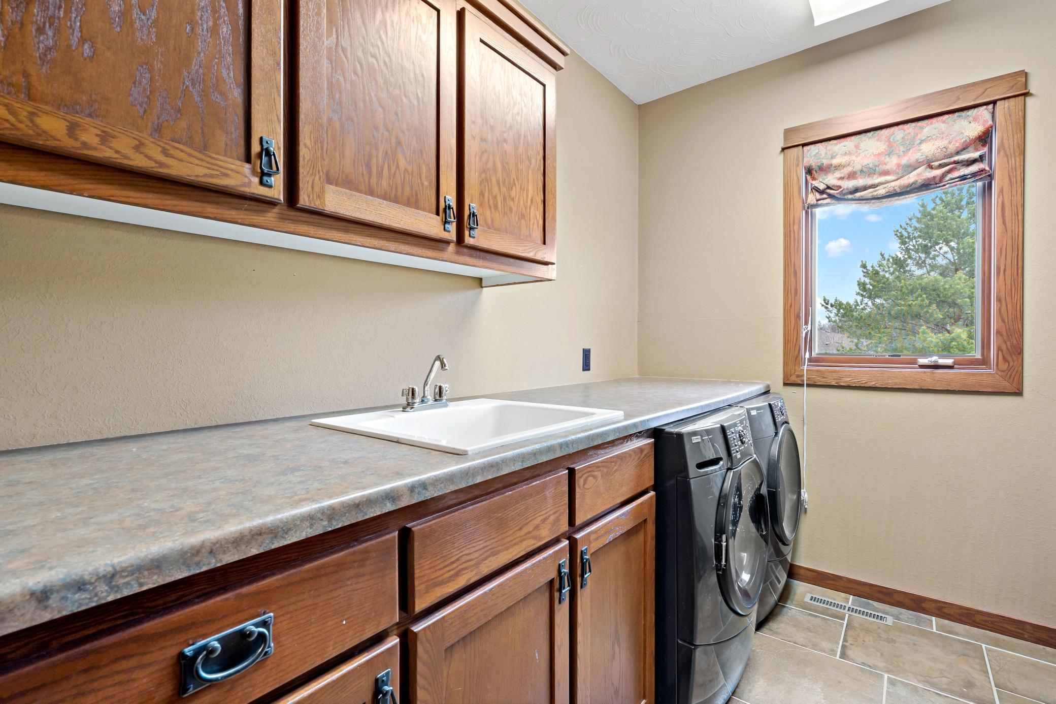Laundry room is a dedicated space of storage, work, and convenience located on the main level and large enough for piles of laundry!