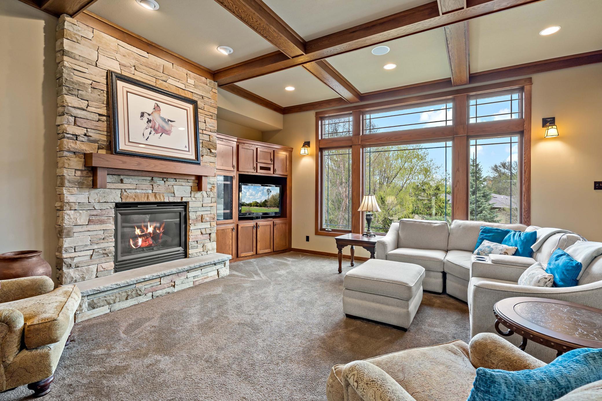 Gas fireplace is surrounded by stone showcasing the intricate details of every feature of this home. Wait until you see the lower level fireplace! The mantle alone is sure to impress!
