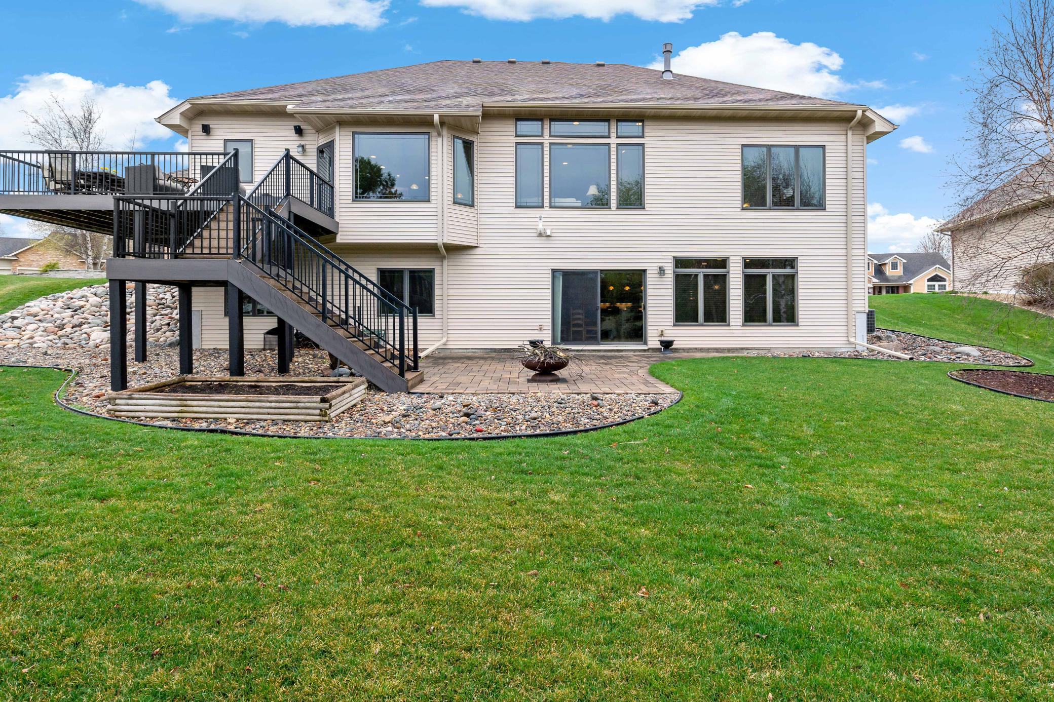 Rear elevation showcasing large paver patio on the lower level and maintenance free deck on the upper level.