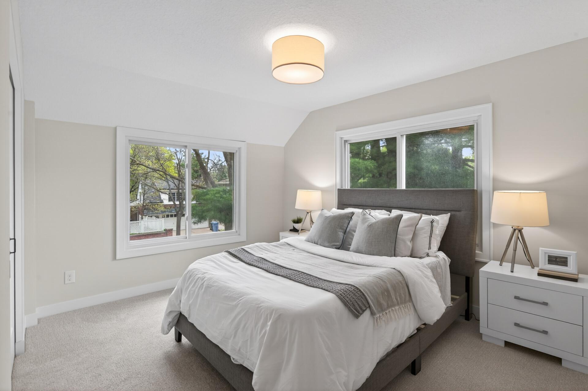 An additional bedroom on the same floor has plenty of natural light and comfortable carpeting.