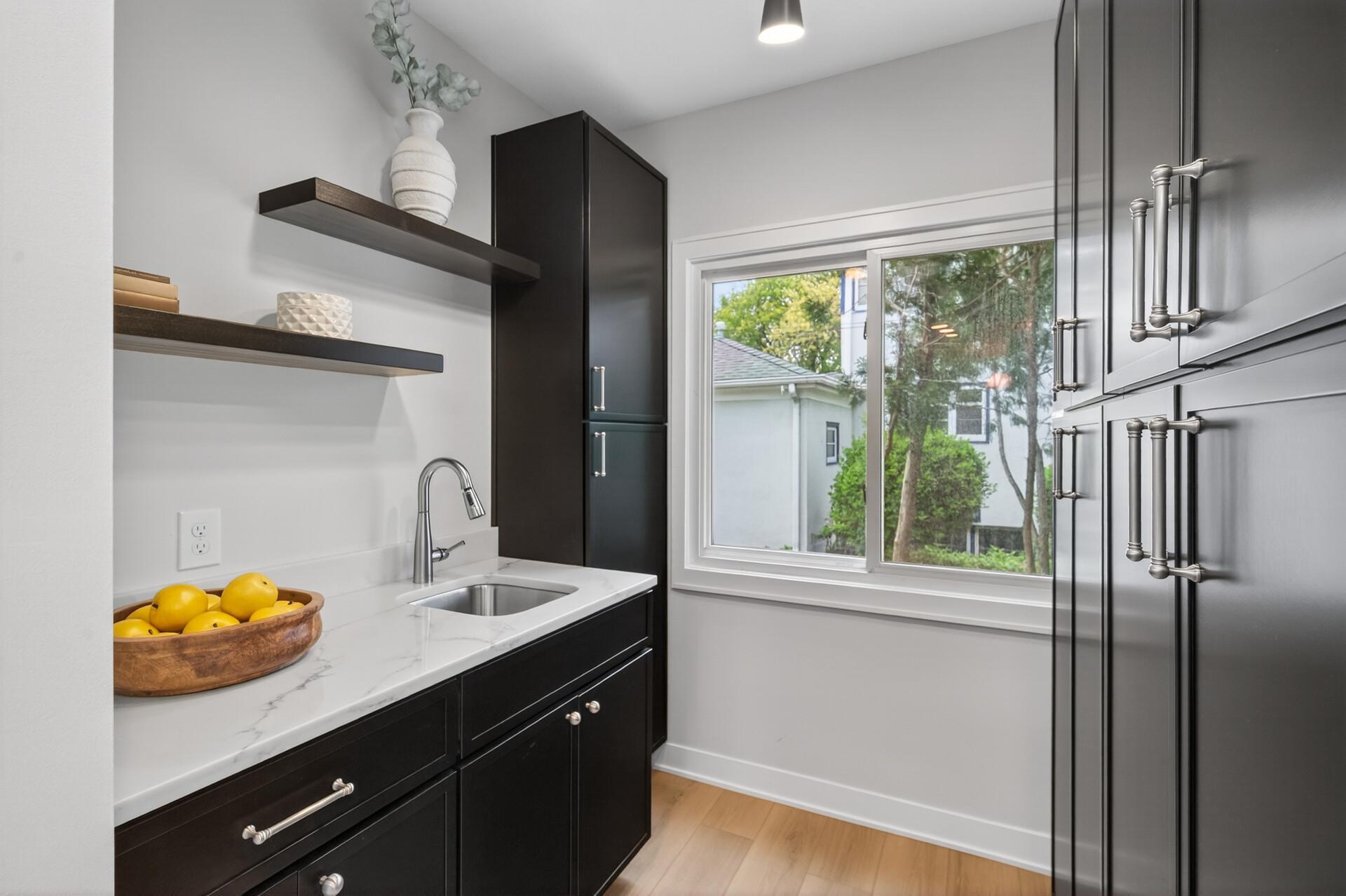 A butler’s pantry adds exceptional storage and prep space with custom cabinetry and a sink.