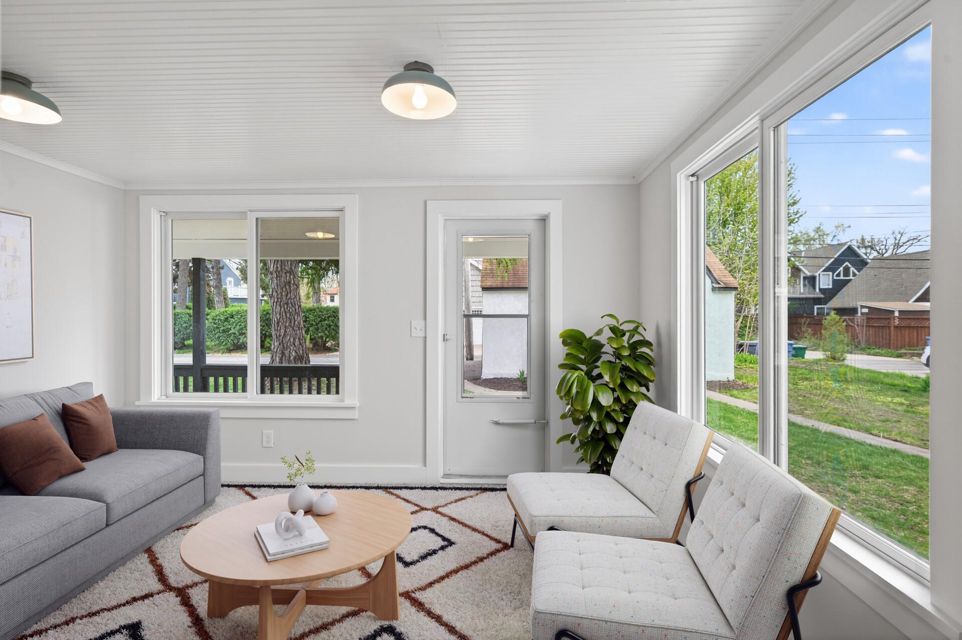 Just beyond, the light-filled three-season porch with updated teak flooring offers a relaxed extension of the home, opening to a covered, maintenance-free deck, perfect for enjoying the outdoors with minimal upkeep.