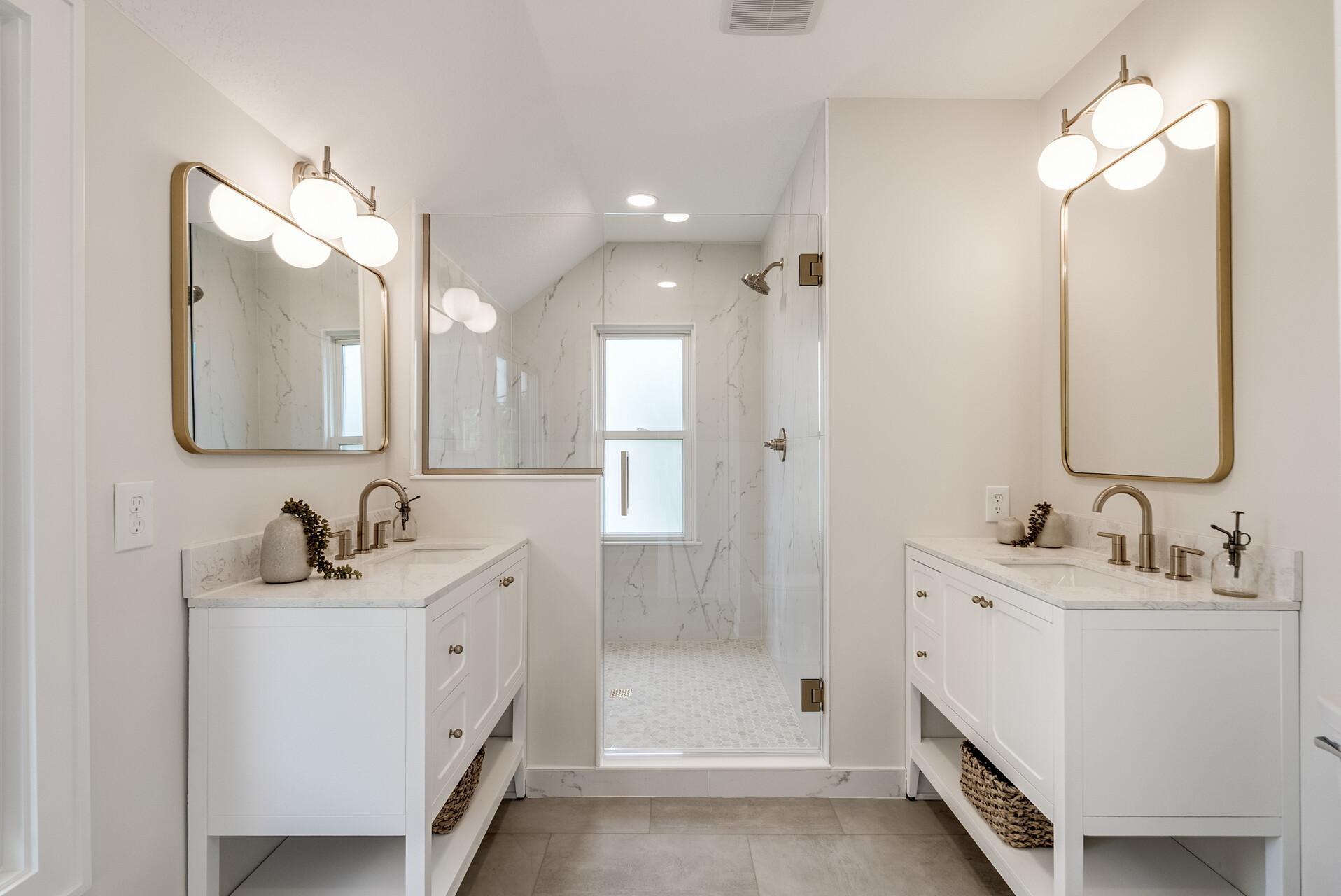 The ensuite bathroom is fully redone with a spacious tiled walk-in shower and dual vanities with built-in outlets for added functionality.