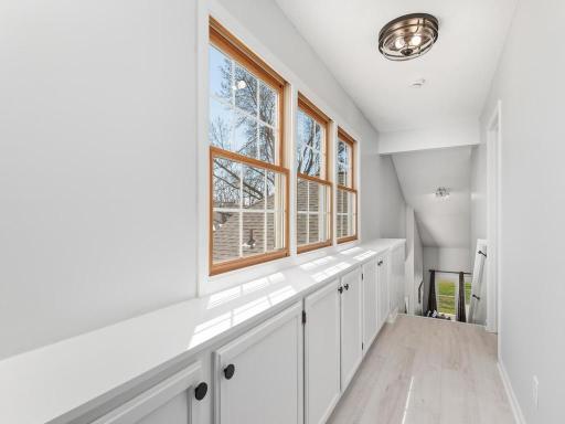 The additional storage lining the hallway and SE-facing windows provide wonderful natural light in this space, offering those with 'green thumbs' more real estate for their plants!