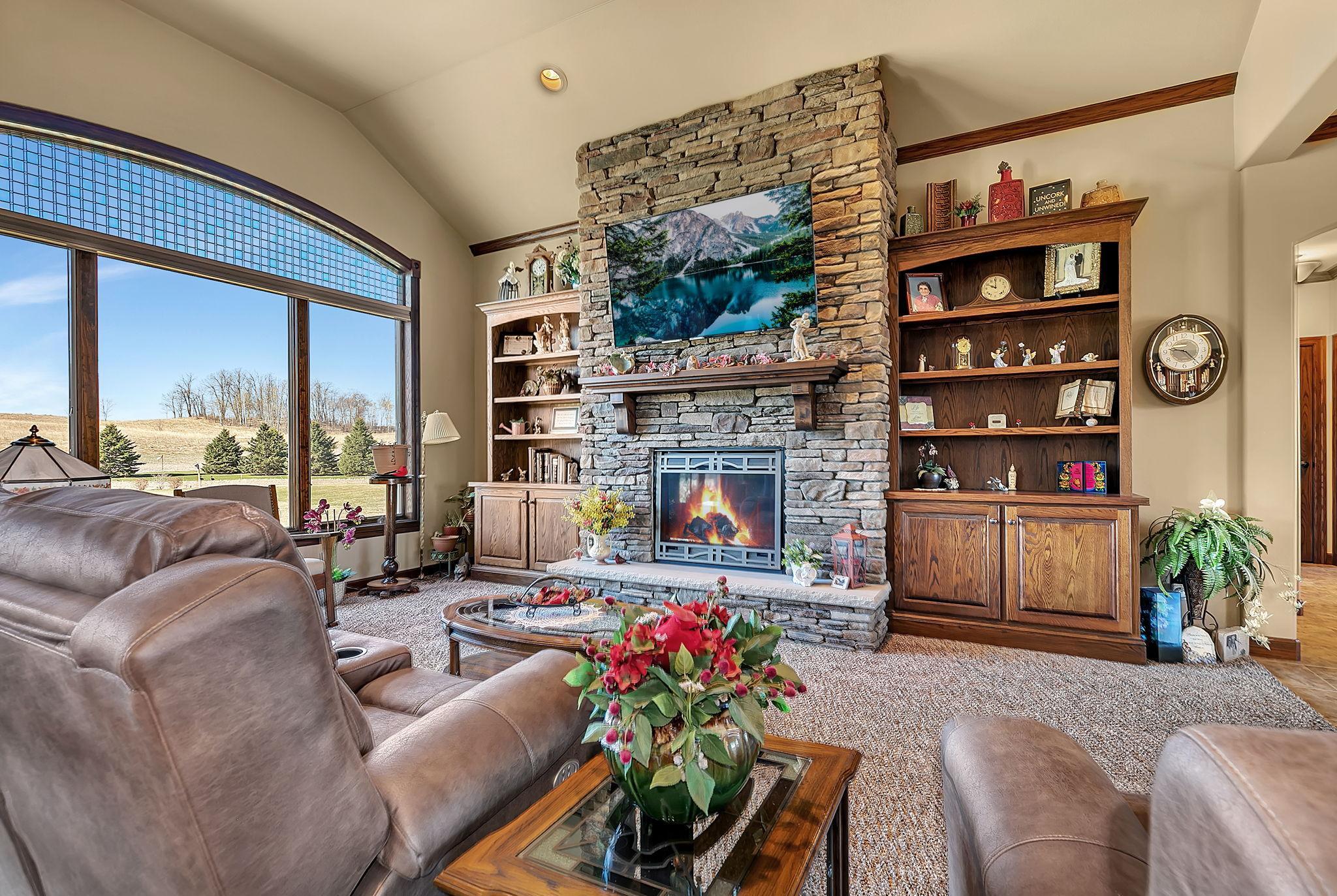 Floor to ceiling stone accents on gas fireplace with hearth & built-in cabinetry