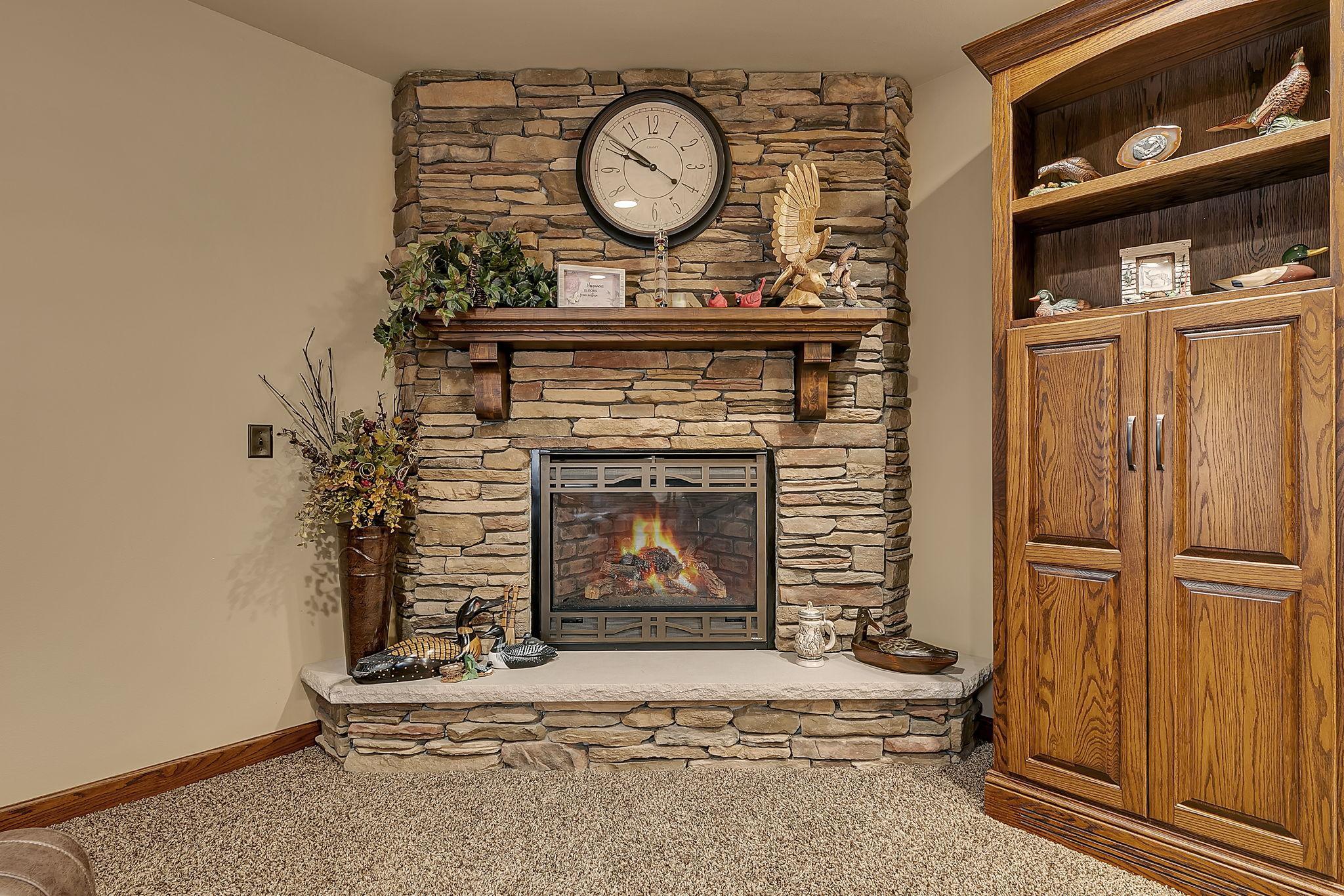 Another gas fireplace in the lower level with floor to ceiling stone