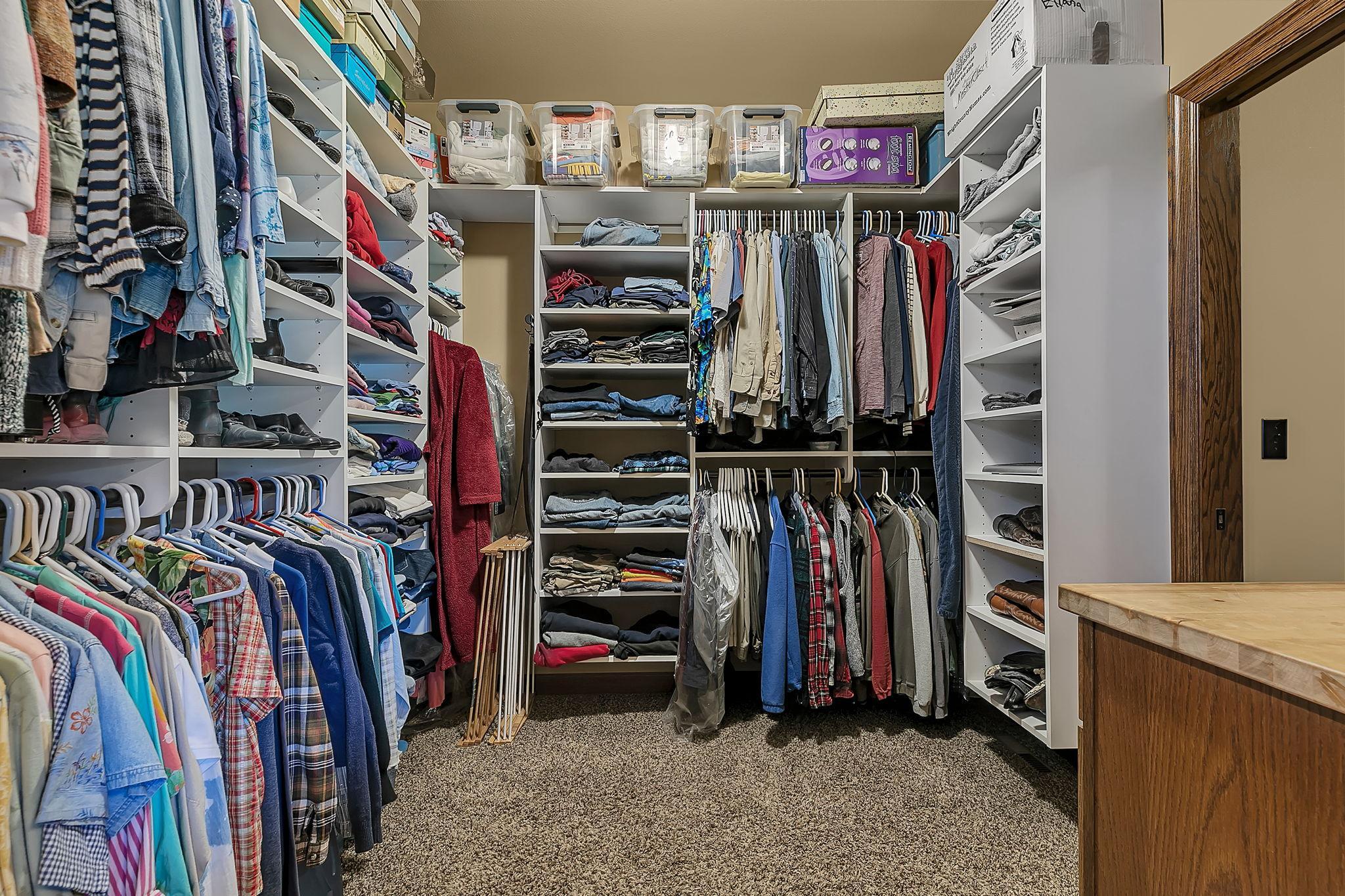 Primary walk-in closet with direct access to bath suite and laundry