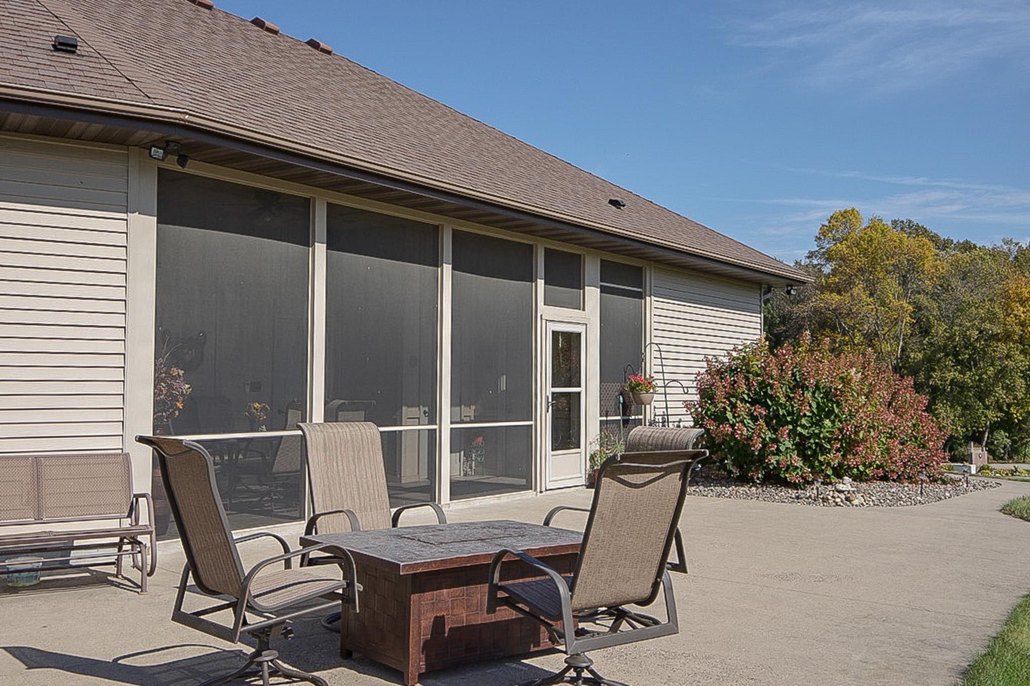 Enclosed screen porch off rear of garage leading out to a large concrete South facing concrete patio