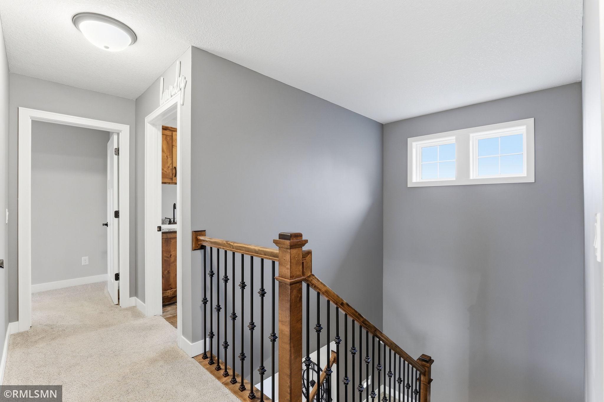 Upper-level landing offers a functional layout with easy access to bedrooms and bathrooms. Bright and open with natural light, creating a comfortable transition between living spaces.
