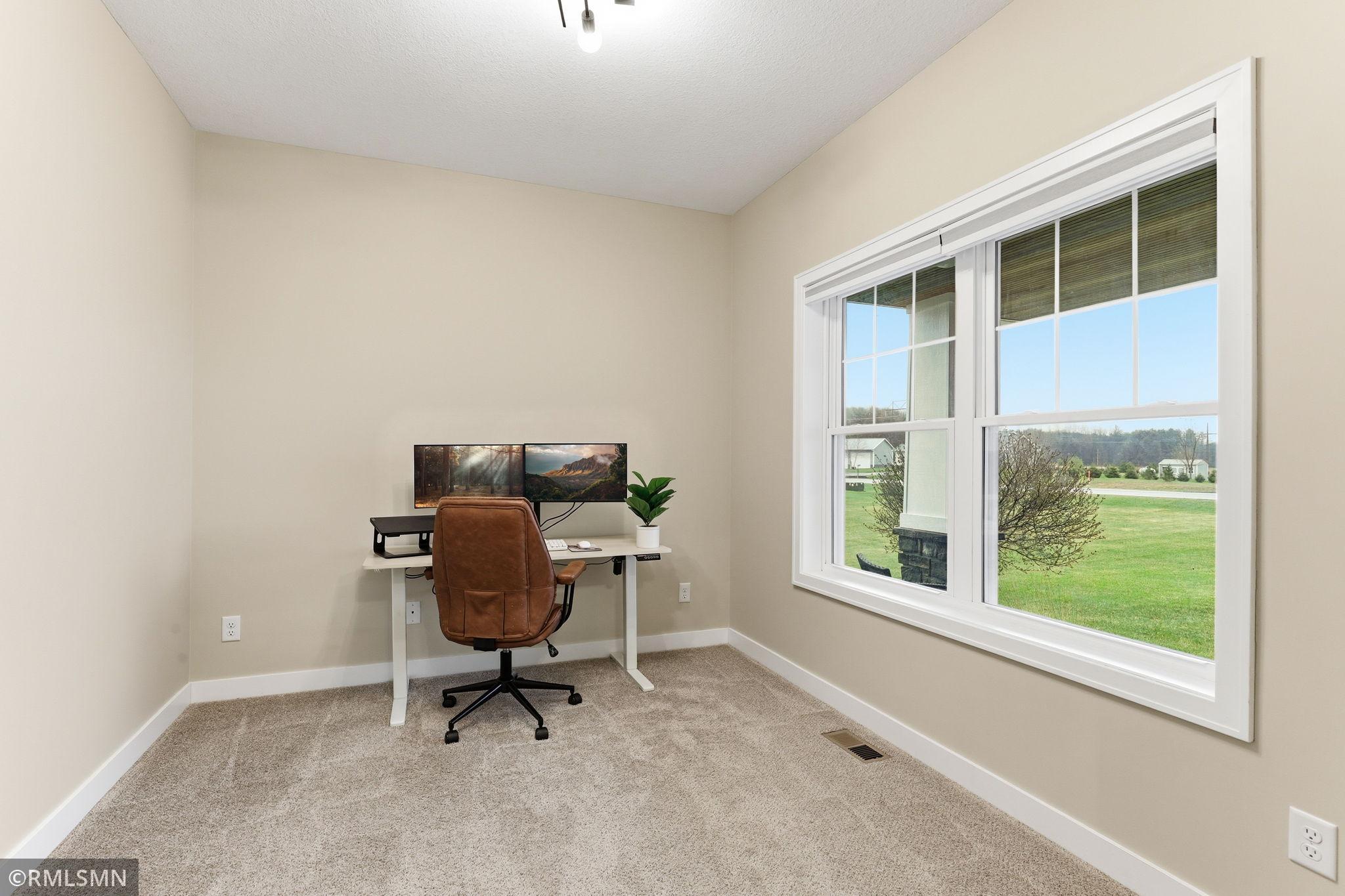 Versatile main floor office or flex-room off the foyer. Large windows fill the room with natural light. Perfect for working from home, studying, or creating a quiet retreat with peaceful views of the surrounding acreage.