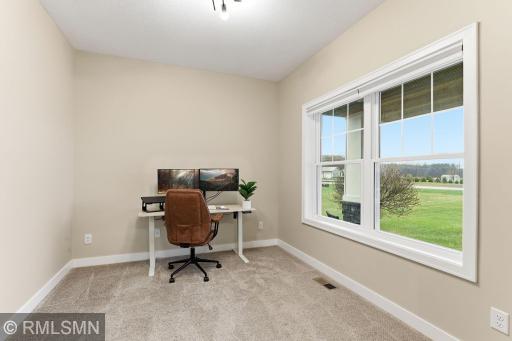 Versatile main floor office or flex-room off the foyer. Large windows fill the room with natural light. Perfect for working from home, studying, or creating a quiet retreat with peaceful views of the surrounding acreage.
