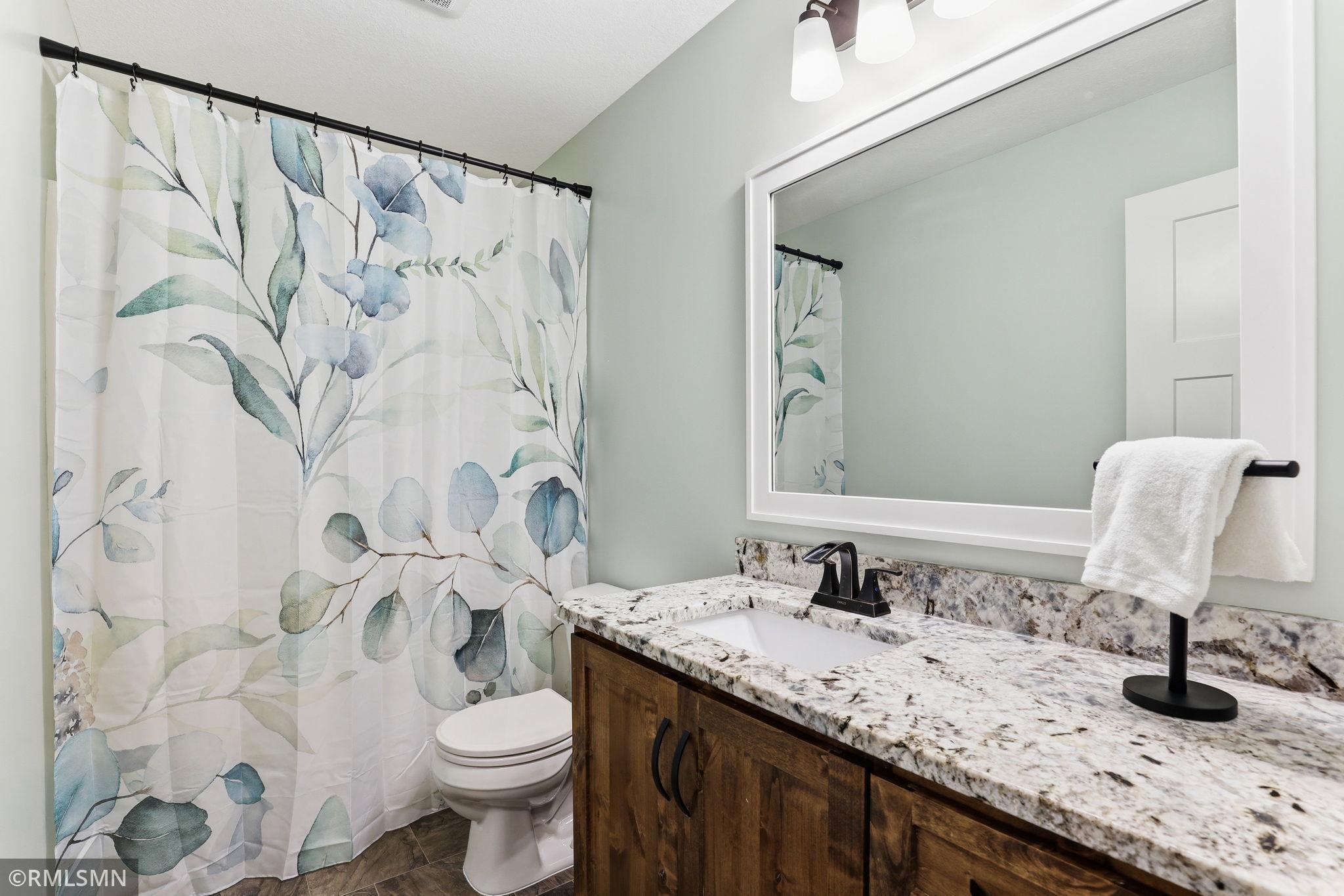 Refresh and unwind in a bright upper-level bath featuring a granite vanity, full tub and shower, and modern finishes. Start and end your day in a clean, comfortable space designed for everyday ease.