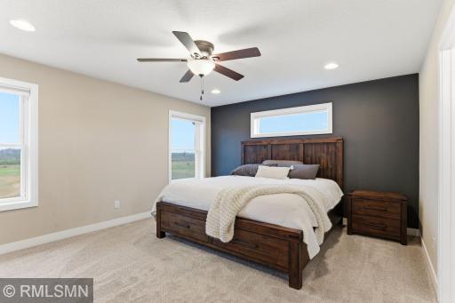 Unwind in the spacious primary bedroom featuring plush carpet, large windows, and peaceful views of the surrounding acreage. Enjoy a calm and comfortable retreat with plenty of natural light.