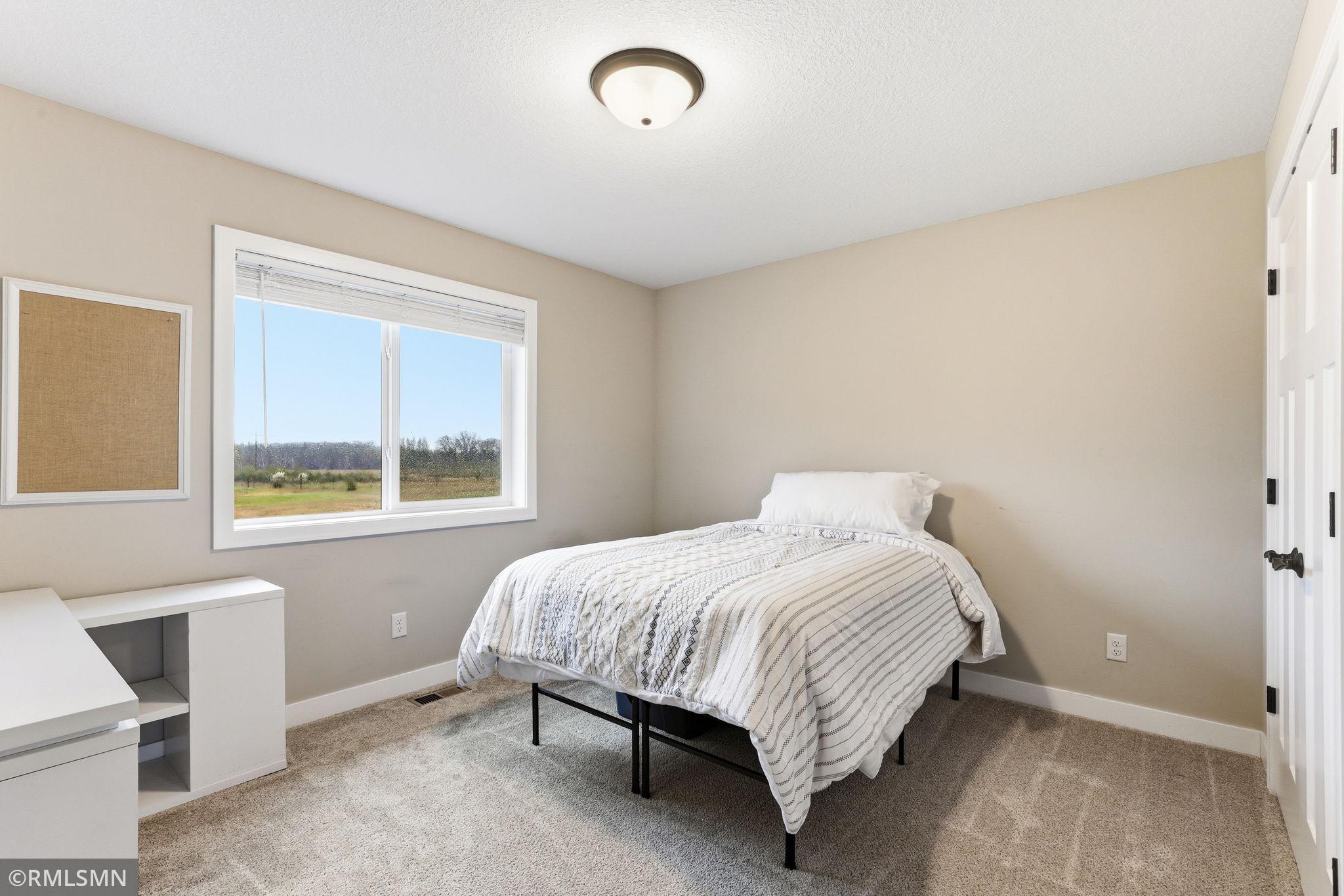 Wake up to natural light in this comfortable bedroom with soft carpet and a large window. Rest, recharge, and enjoy a peaceful space to start and end your day.