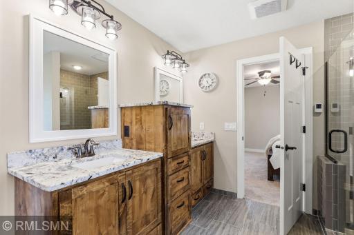 Spread out and get ready without feeling rushed in this thoughtfully designed bathroom with separate vanities and ample storage.