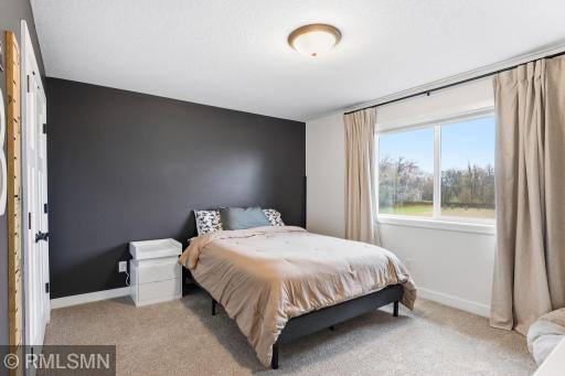 Settle in and relax in this comfortable upper bedroom with soft carpet and natural light. Unwind, recharge, and enjoy a cozy space to call your own.