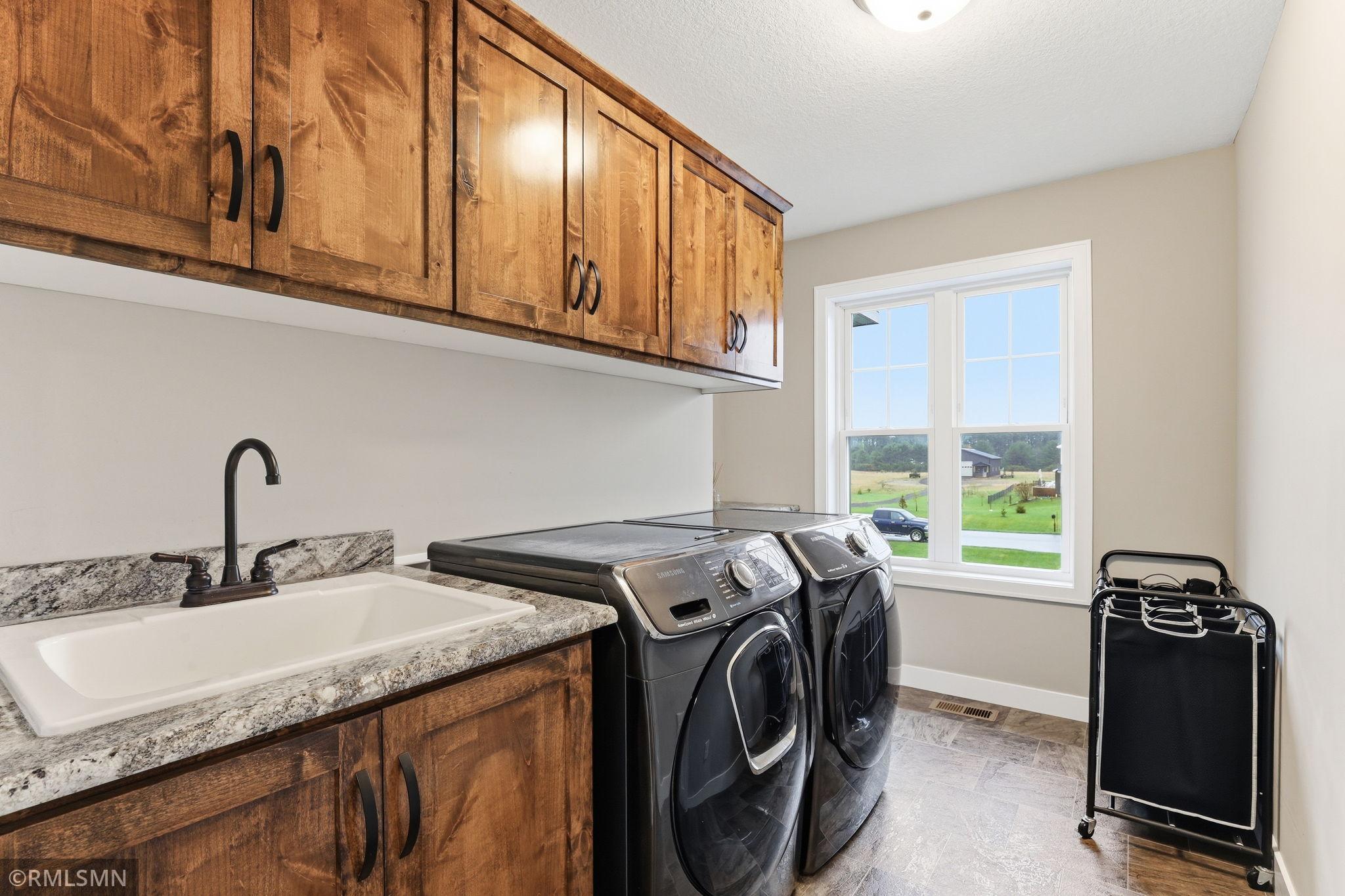 Take advantage of a bright, functional laundry room with ample cabinetry and a utility sink. Stay organized, streamline daily chores, and enjoy natural light pouring in from the large window.