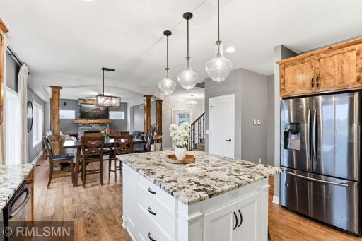 Gather around the spacious dining area while staying connected to the kitchen. Enjoy hosting and everyday meals with an open layout, warm wood finishes, and natural light pouring in from the surrounding windows.