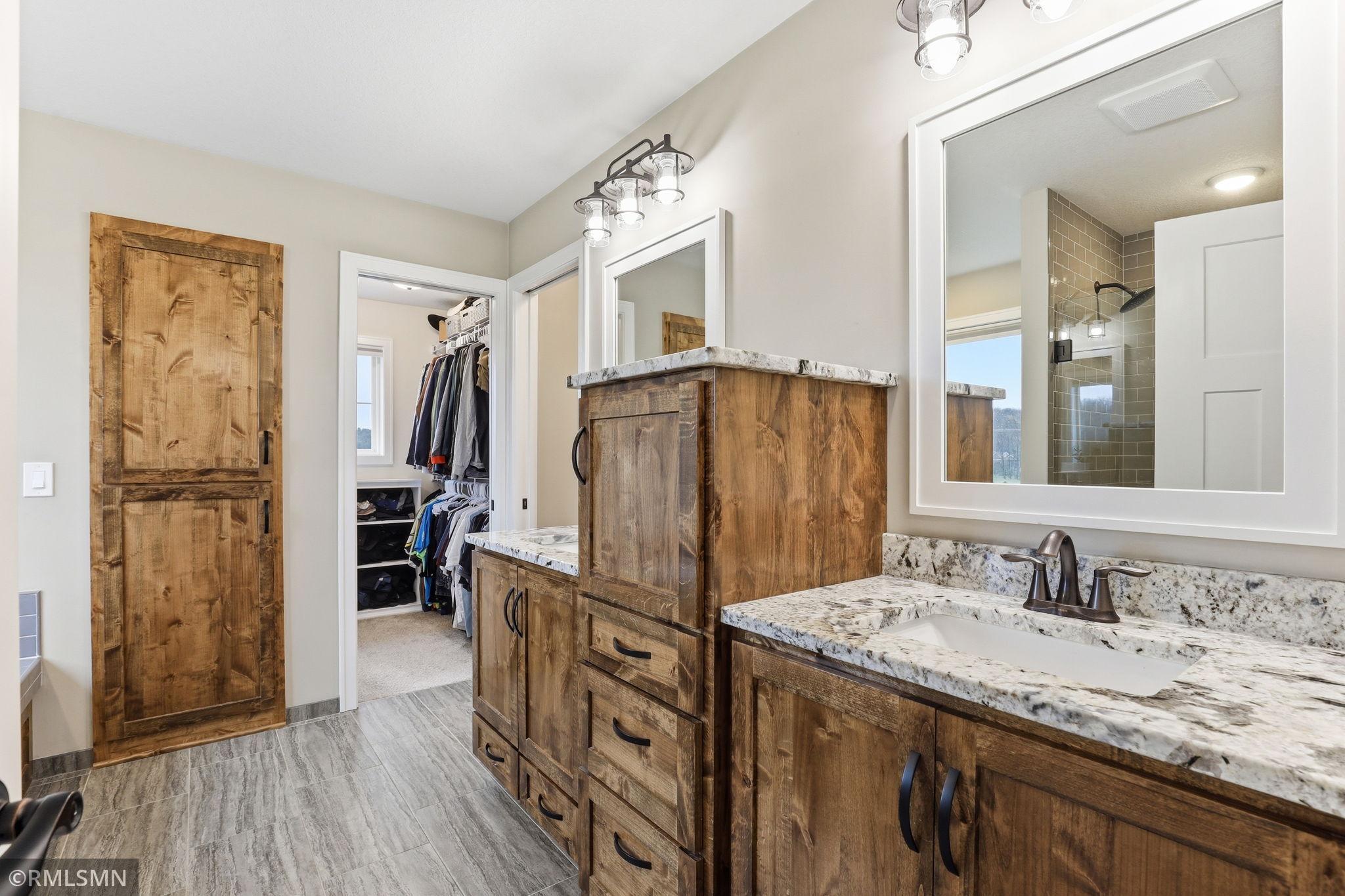 Start your day with ease in this dual vanity layout featuring granite countertops, rich wood cabinetry, and direct access to a spacious walk-in closet. Stay organized, get ready comfortably, and enjoy the added privacy of a separate toilet room.