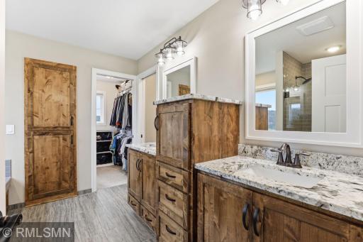 Start your day with ease in this dual vanity layout featuring granite countertops, rich wood cabinetry, and direct access to a spacious walk-in closet. Stay organized, get ready comfortably, and enjoy the added privacy of a separate toilet room.