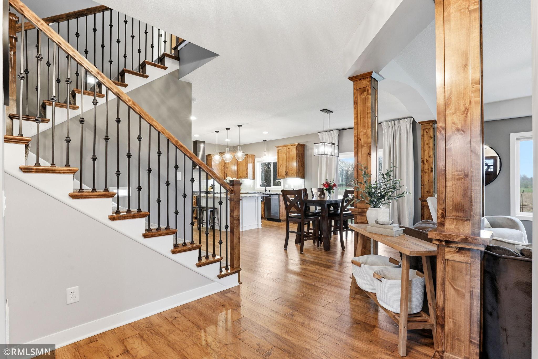 Open and inviting main level featuring rich hardwood floors, custom woodwork, and a seamless flow between the living, dining, and kitchen areas, perfect for everyday living and entertaining.