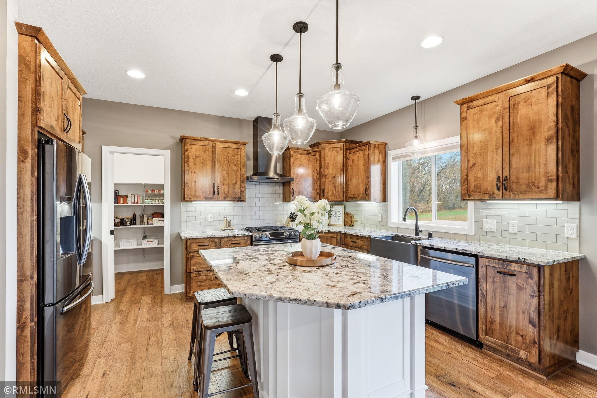 Prep meals at the large center island while staying connected to the rest of the home. Enjoy the farmhouse sink, ample counter space, and bright windows that bring in natural light and peaceful views.