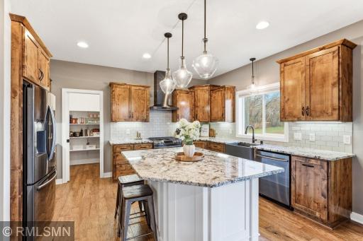 Prep meals at the large center island while staying connected to the rest of the home. Enjoy the farmhouse sink, ample counter space, and bright windows that bring in natural light and peaceful views.