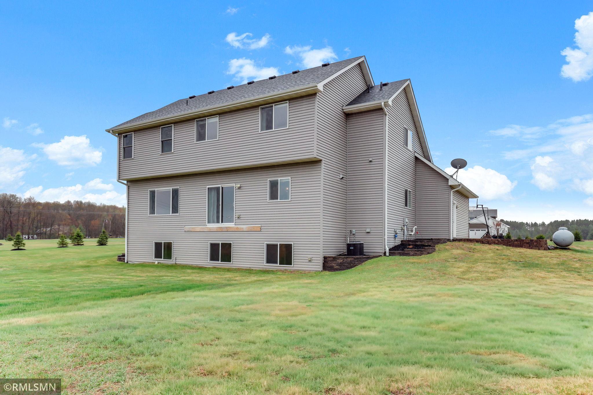 Appreciate the expansive backyard and rear elevation featuring multiple daylight windows, offering great potential to expand outdoor living or finish the lower level to fit your needs.
