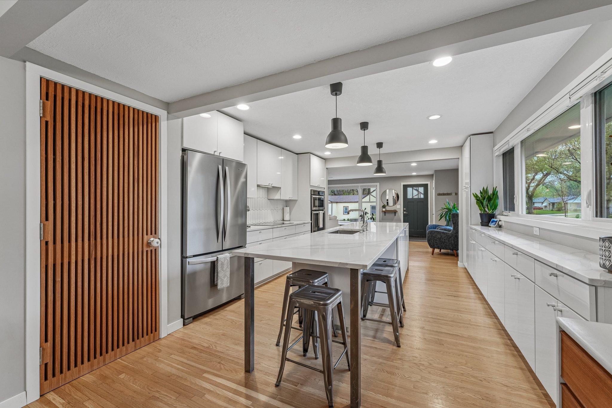 Admire the custom pantry door that adds warmth and personality to this already gorgeous kitchen.