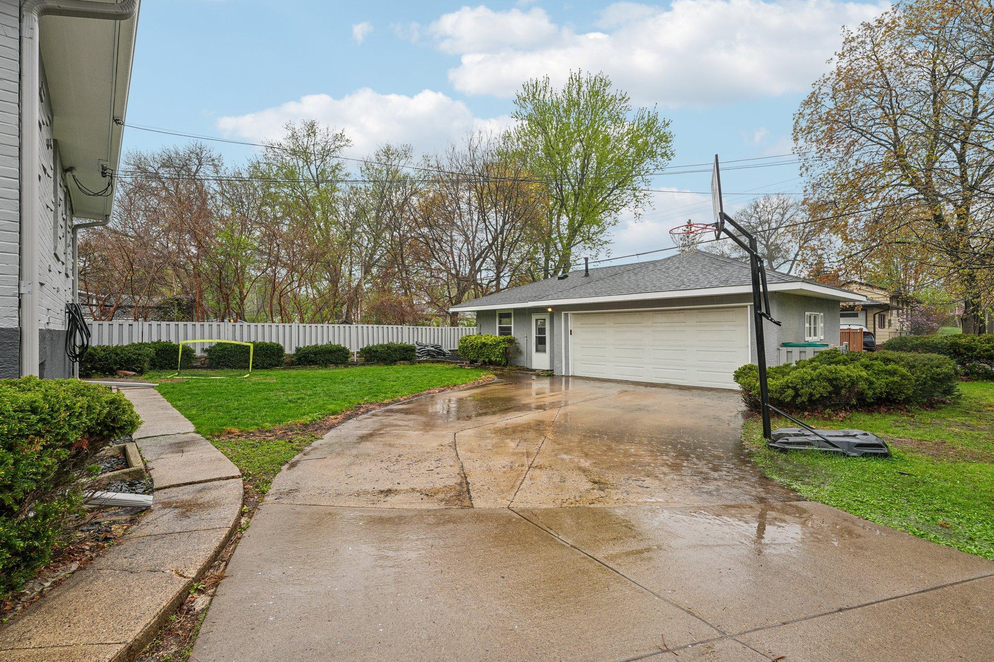 A concrete driveway leads you to the 2-car garage with an attached workshop—an ideal setup for hobbies, projects, storage, or the ultimate DIY dream space.
