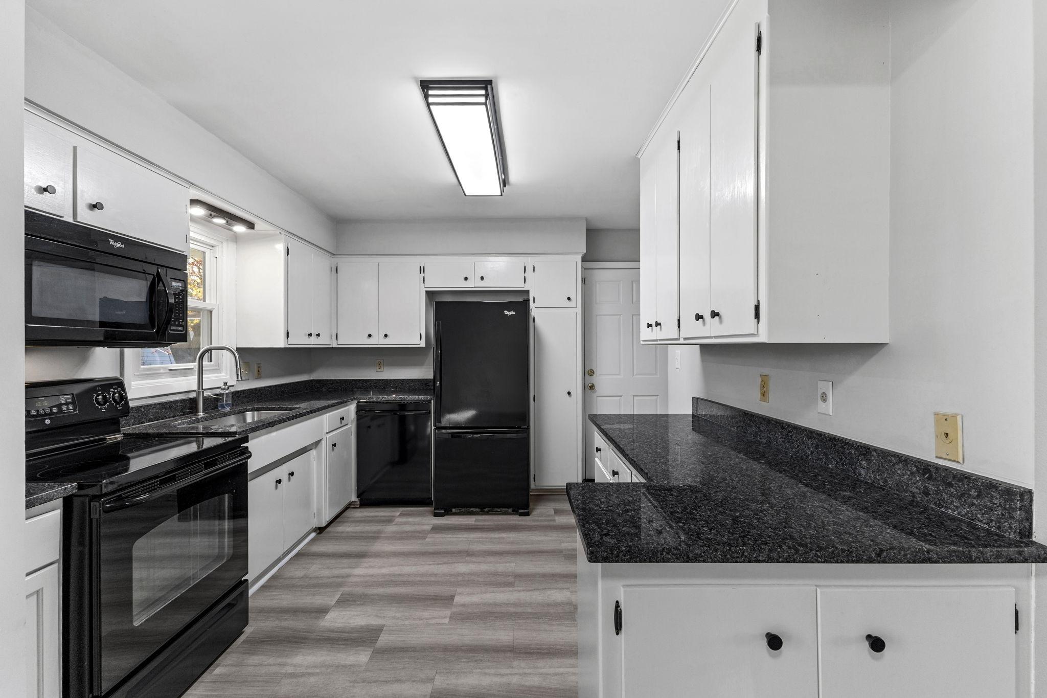 Granite counters, undermount sink and freshly painted cabinets.