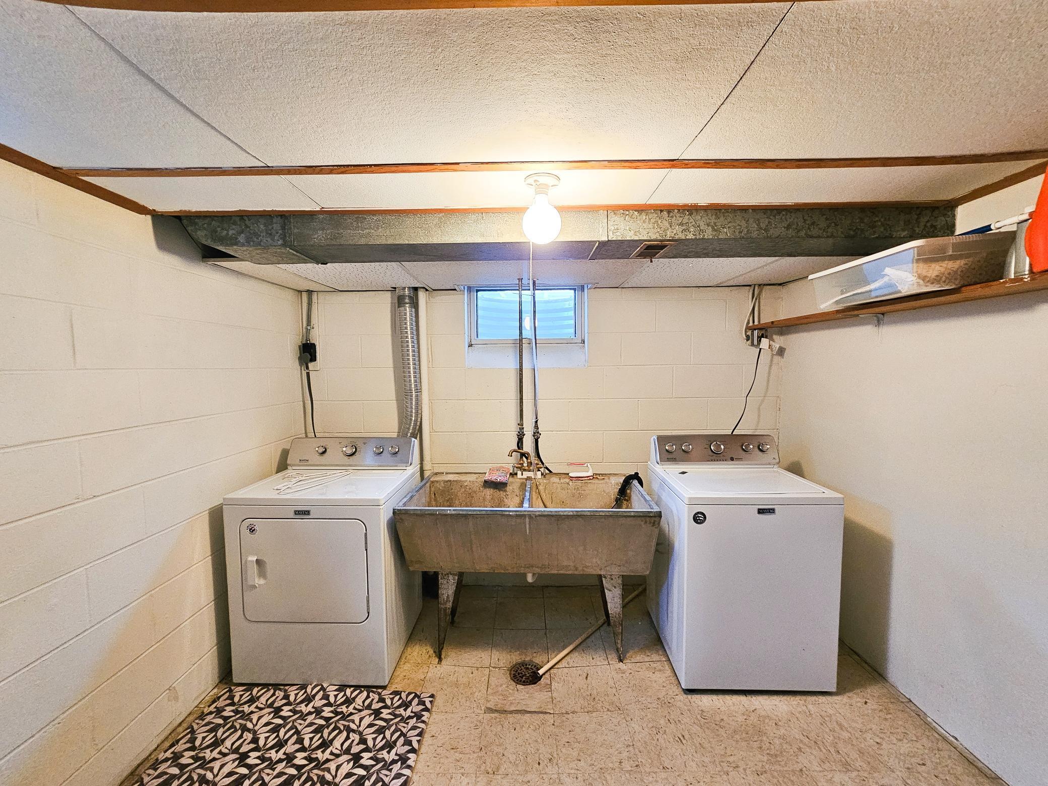 Dry and clean laundry room with newer washer and dryer