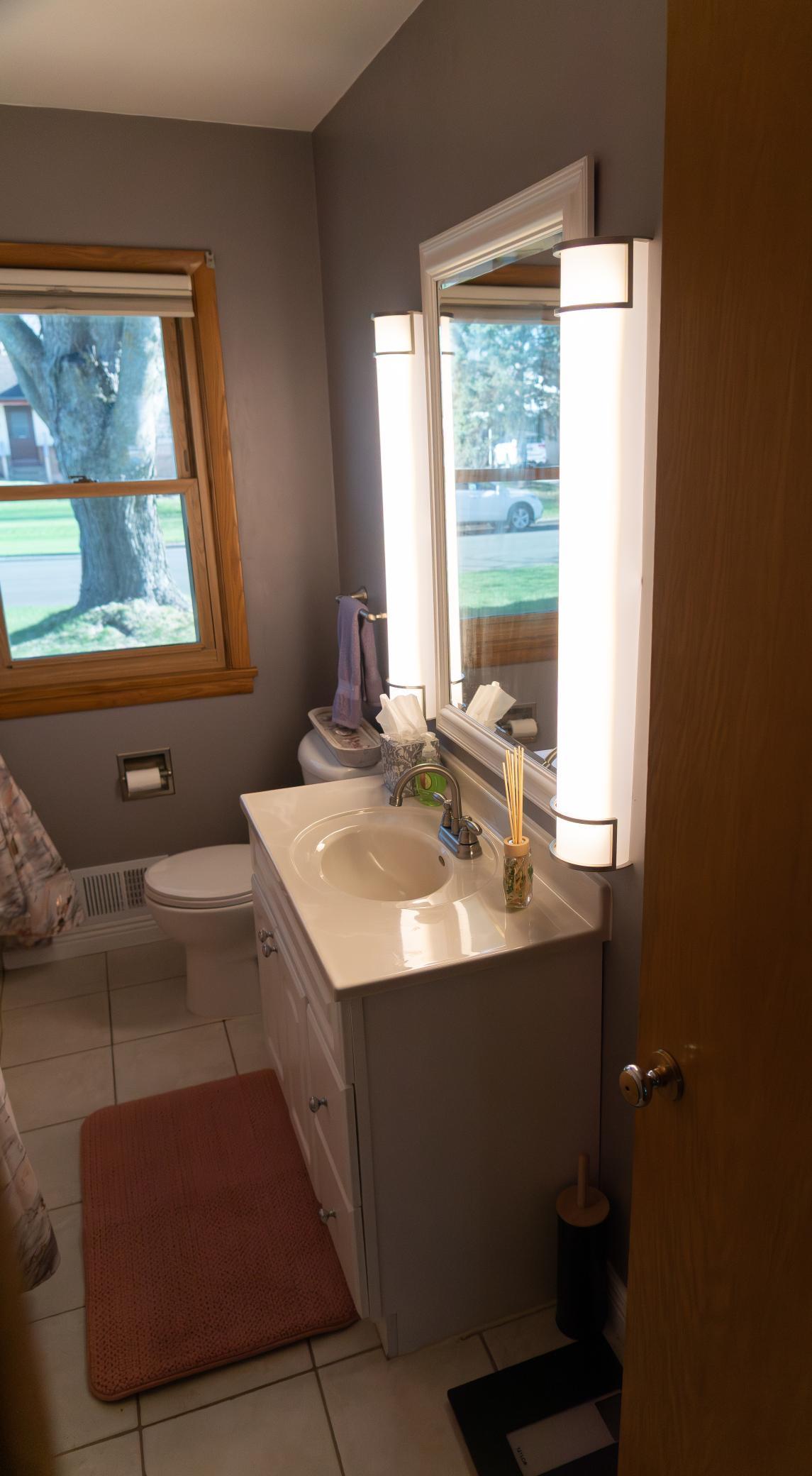 The modern main level bathroom features tile floor, tile tub, newer vanity, and fresh paint