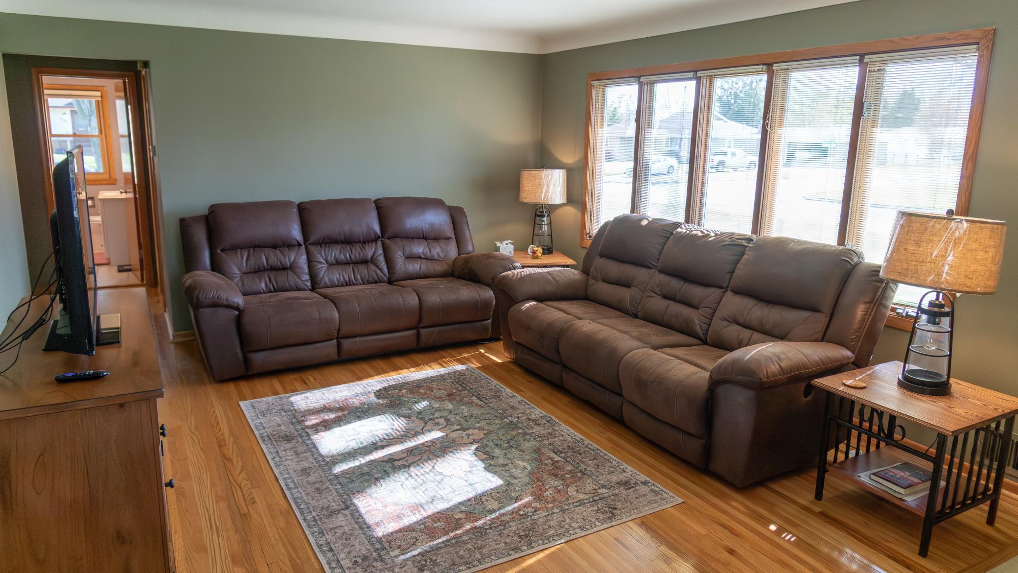 The expansive living area features coved ceilings, rich hardwood floors, functional tile entryway, large windows flood the room with natural light