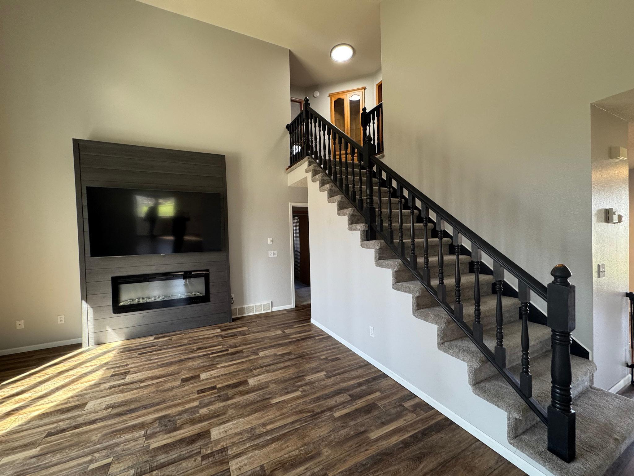 Soaring two story living room with electric fireplace.