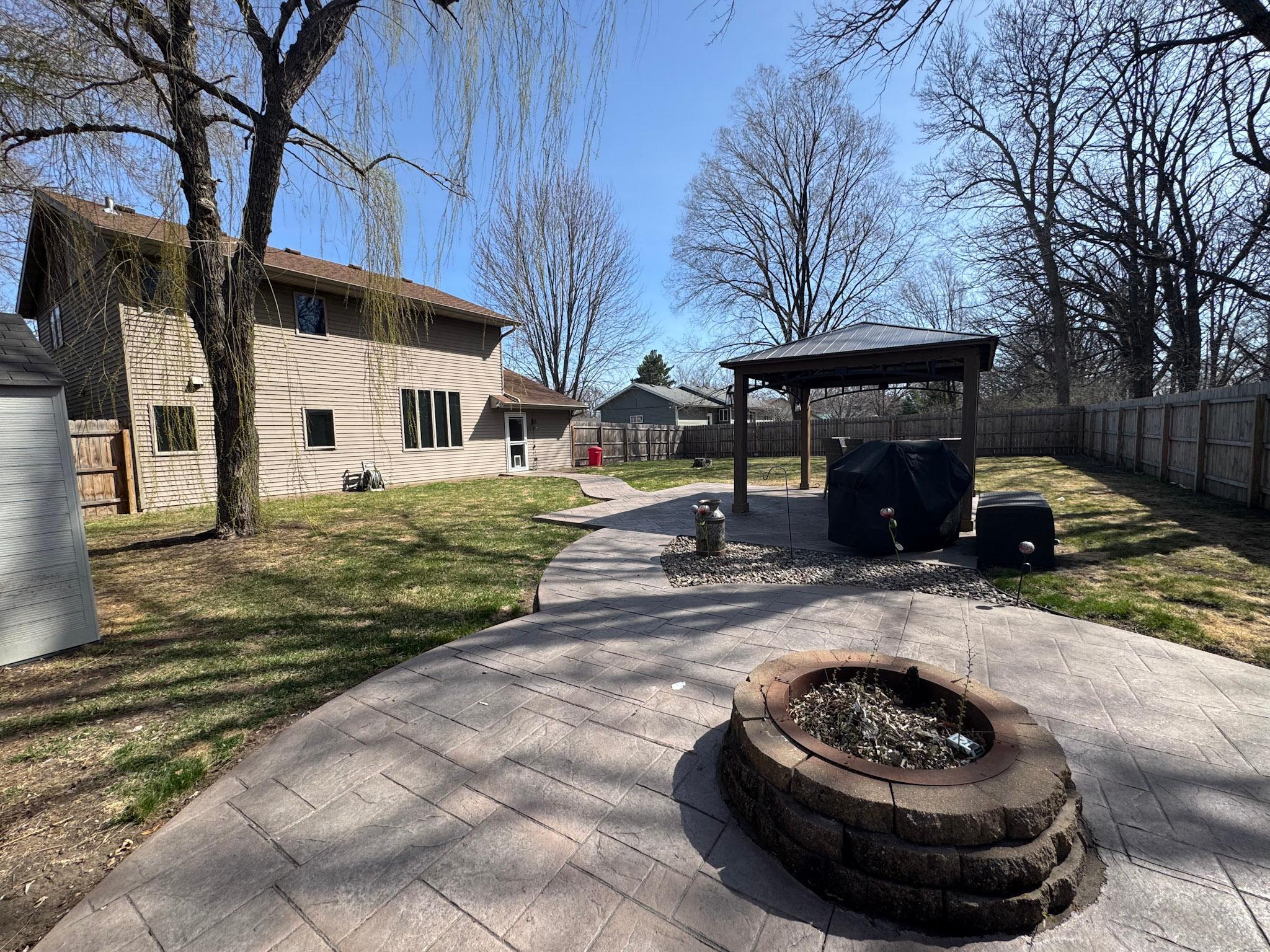 Privacy fenced backyard oasis waiting for you! Stamped concrete patio with firepit and gazebo.