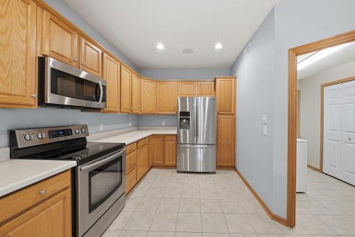 Kitchen with stainless steel appliances and the laundry room to the right.