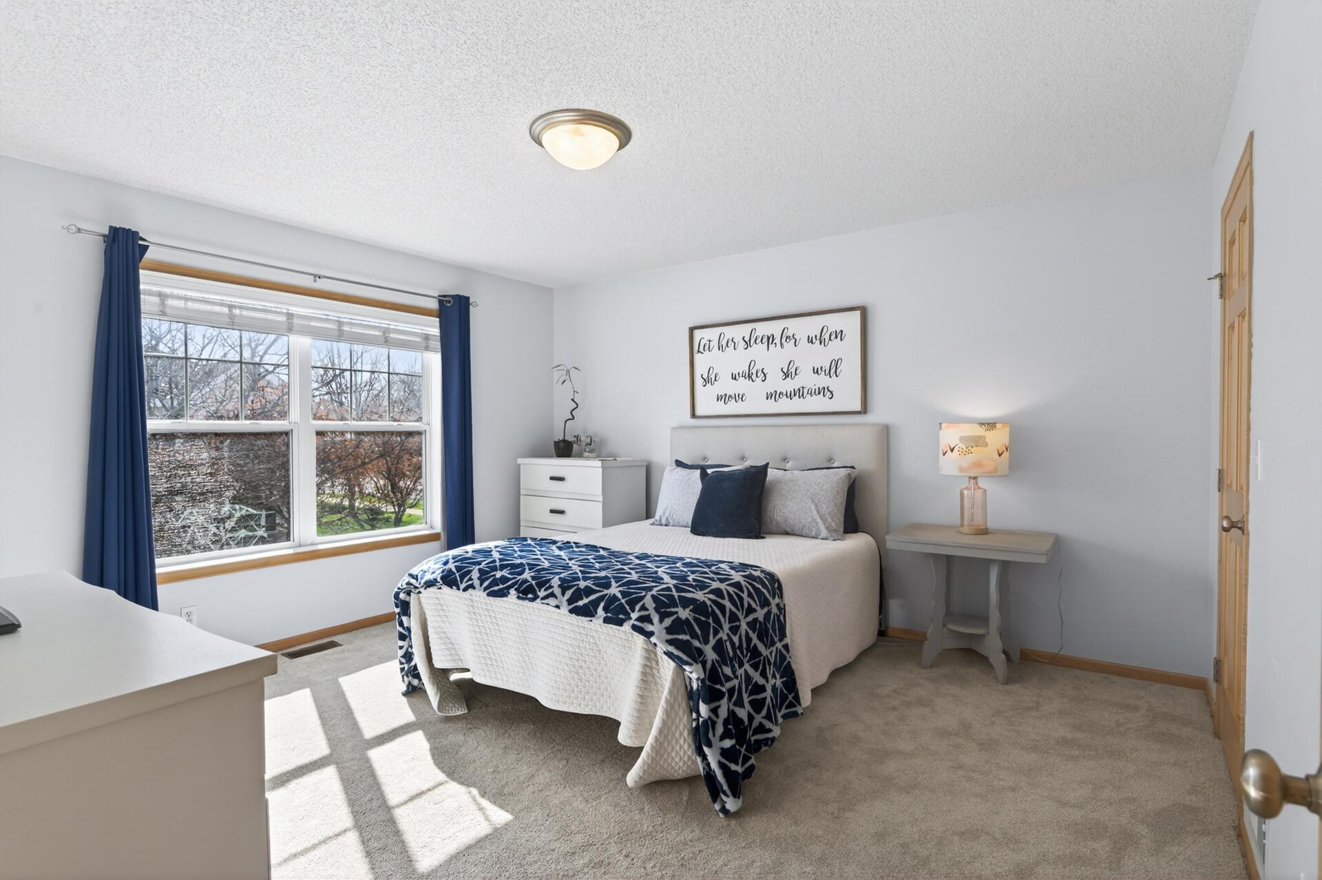 Upstairs primary bedroom with oversized windows and a large walk-in closet.