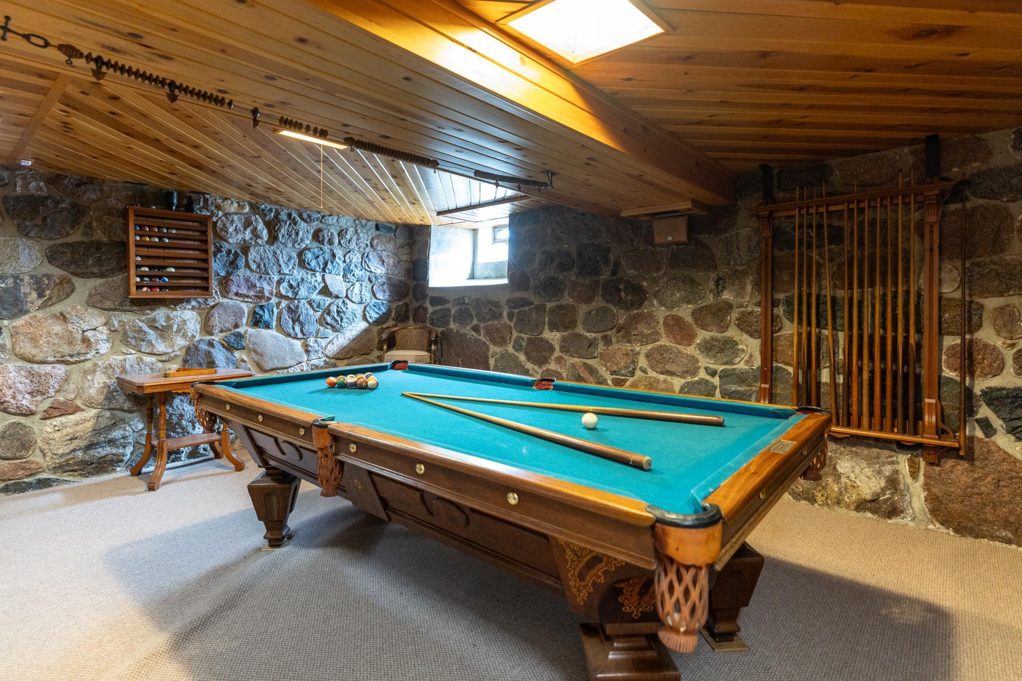 This vintage 100 year old pool table accents the beautiful stone walls and wood ceiling